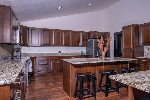 44 Copper Ridge Rd, Trout Creek, MT 59874 - kitchen with a breakfast bar, dark brown cabinetry, stainless steel electric range, dark wood-style flooring, and refrigerator with ice dispenser