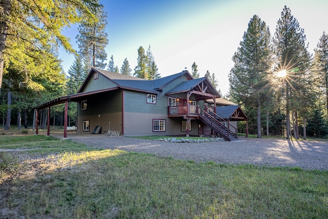 rear view of house featuring a yard and a wooden deck