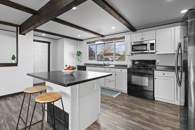 kitchen with white cabinets, beamed ceiling, a breakfast bar area, and black appliances