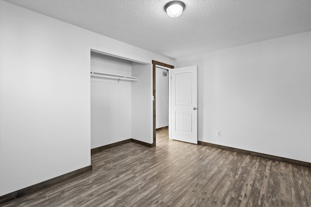 unfurnished bedroom with a closet, dark wood-type flooring, and a textured ceiling