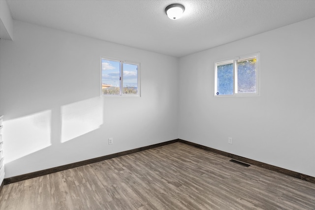 empty room featuring hardwood / wood-style flooring and a textured ceiling