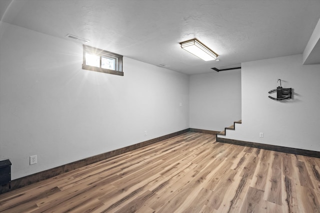 basement with wood-type flooring and a textured ceiling