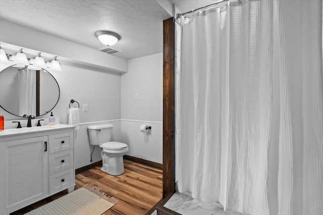 bathroom featuring vanity, wood-type flooring, and toilet