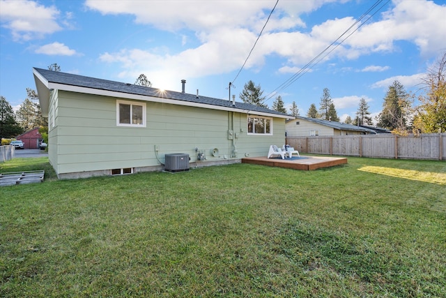 back of property with a lawn, a deck, and central air condition unit