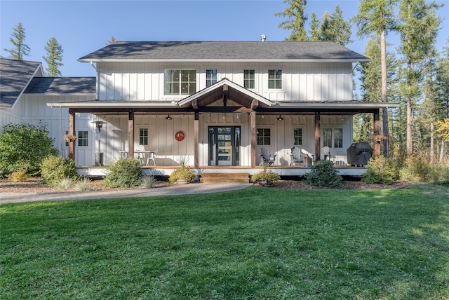 modern inspired farmhouse featuring covered porch and a front yard