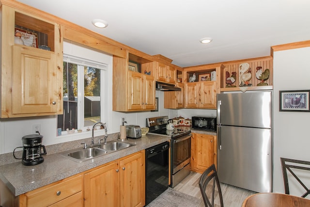 kitchen featuring light brown cabinetry, sink, black appliances, and light wood-type flooring