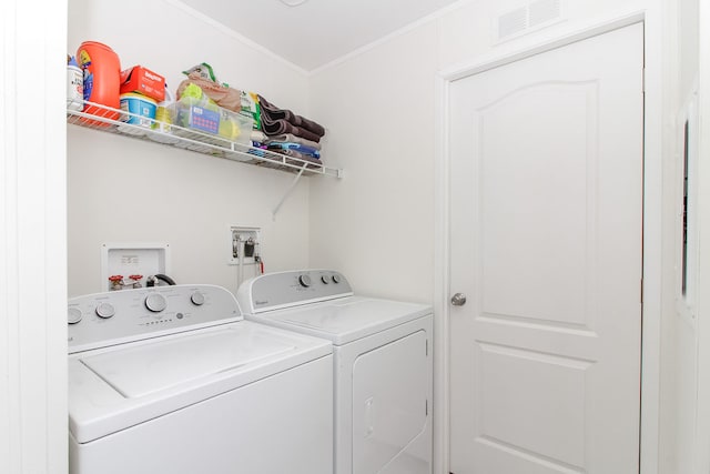 laundry room with independent washer and dryer and crown molding