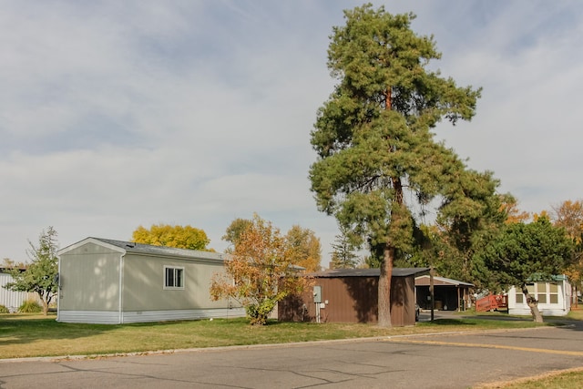 view of front of property featuring a front lawn and a carport