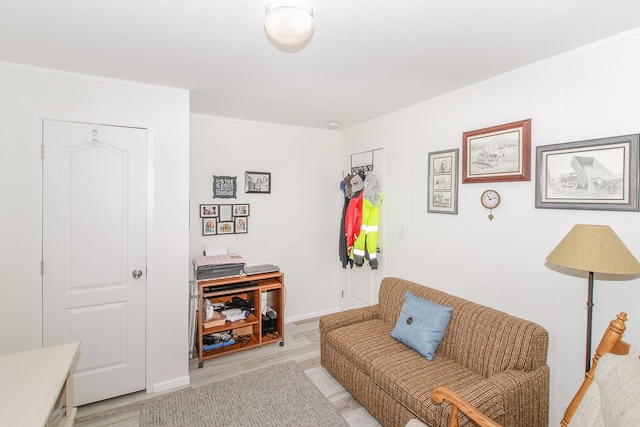 living area featuring crown molding and light wood-type flooring