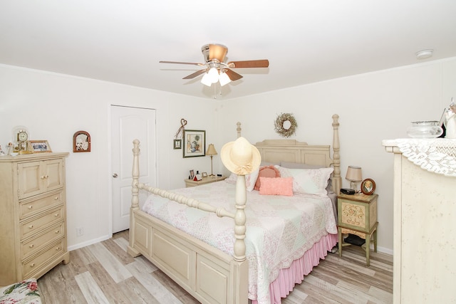 bedroom featuring ceiling fan, ornamental molding, and light wood-type flooring