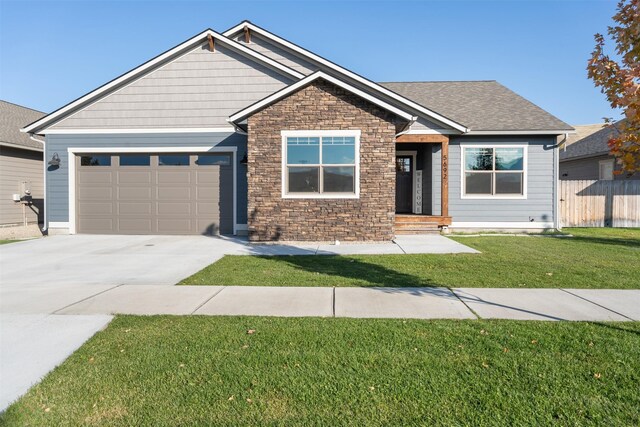 craftsman inspired home with a garage and a front lawn