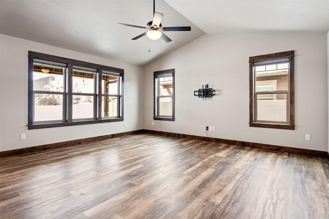 empty room with ceiling fan, vaulted ceiling, and wood-type flooring