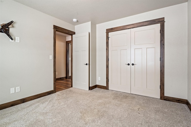 unfurnished bedroom featuring a closet and dark colored carpet