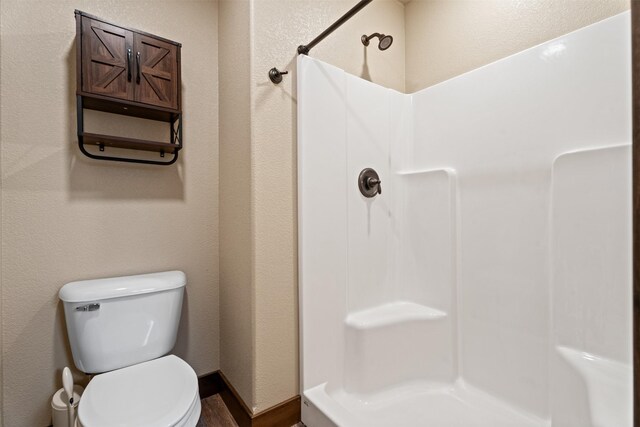 bathroom featuring a shower and toilet