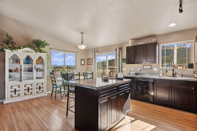 28 W Ashley Hills Dr, Kalispell, MT 59901 - kitchen featuring black dishwasher, a sink, light wood-type flooring, a breakfast bar, and lofted ceiling
