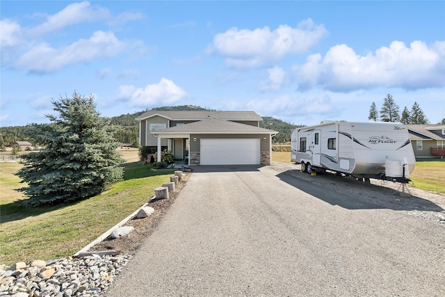 28 W Ashley Hills Dr, Kalispell, MT 59901 - split level home featuring a front lawn, stone siding, driveway, and a garage
