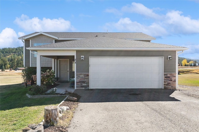 28 W Ashley Hills Dr, Kalispell, MT 59901 - view of front facade with stone siding, an attached garage, roof with shingles, and driveway