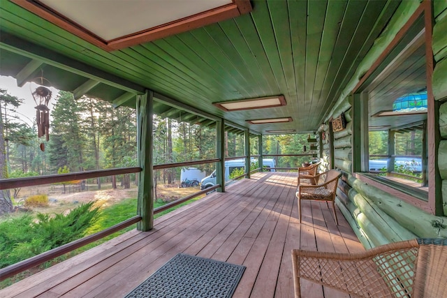 sunroom / solarium featuring wooden ceiling, plenty of natural light, and lofted ceiling