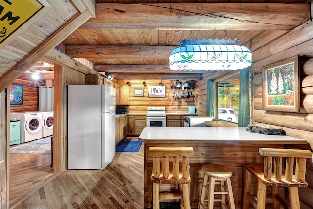 kitchen with range, white refrigerator, washing machine and dryer, light hardwood / wood-style floors, and kitchen peninsula