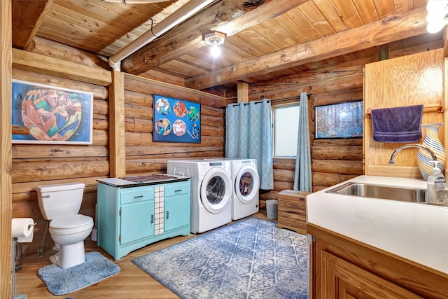 clothes washing area featuring wooden ceiling, sink, light wood-type flooring, rustic walls, and washing machine and clothes dryer