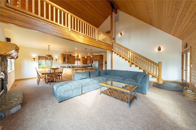 carpeted living room with wood ceiling, a fireplace, beam ceiling, and high vaulted ceiling