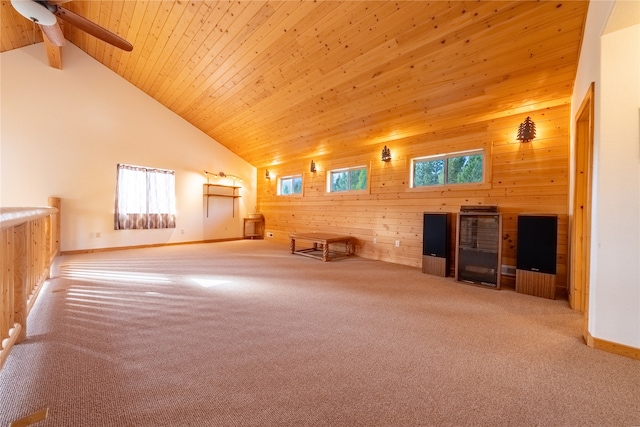 interior space with wood walls, carpet flooring, high vaulted ceiling, and a wealth of natural light