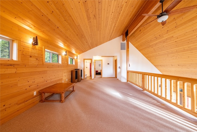 corridor with carpet, lofted ceiling with beams, wood walls, and wood ceiling