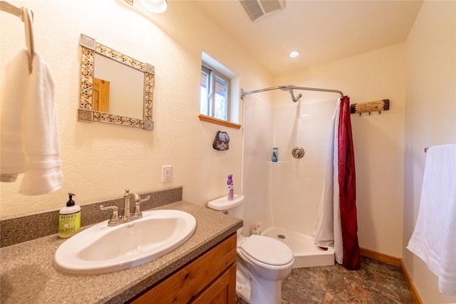 bathroom with walk in shower, vanity, and toilet