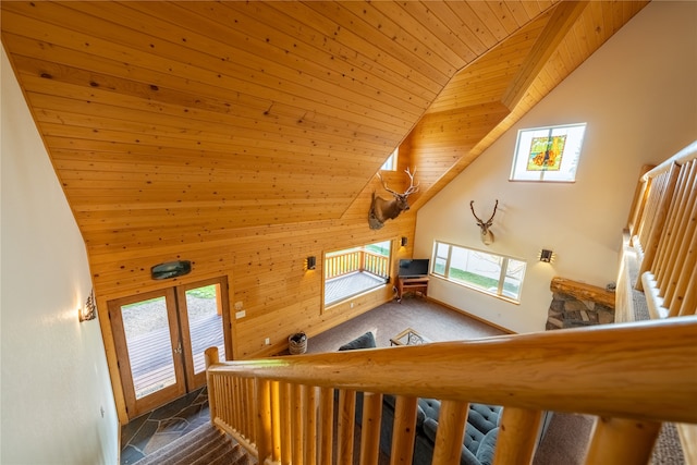 staircase featuring wood walls, french doors, wooden ceiling, and high vaulted ceiling