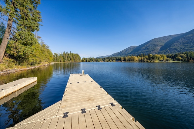 view of dock with a water and mountain view