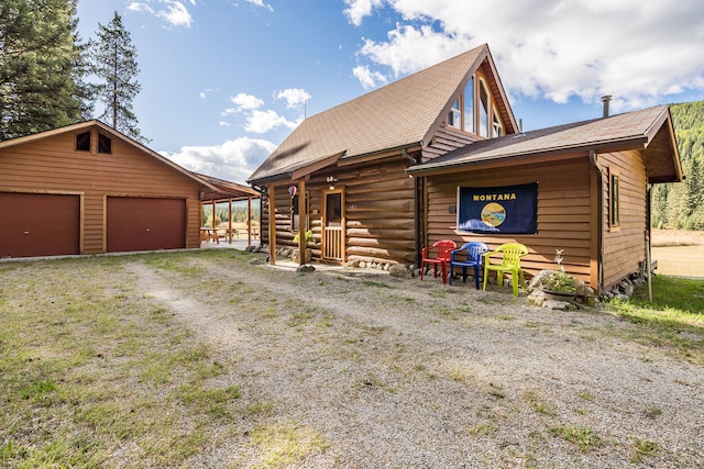 log cabin with a garage and a front lawn