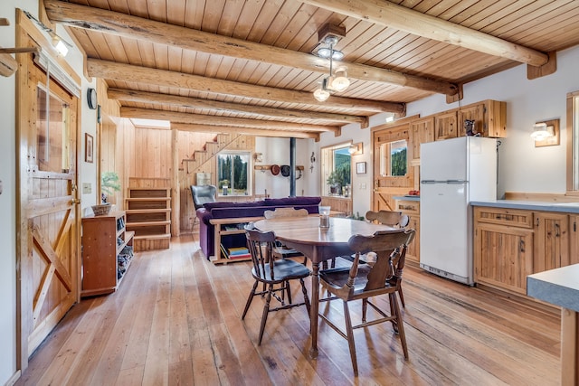 dining space featuring wood walls, light hardwood / wood-style floors, wooden ceiling, and beam ceiling