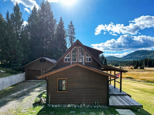 view of side of property with a mountain view, a garage, and a lawn