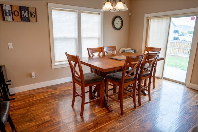 dining area featuring dark hardwood / wood-style flooring and an inviting chandelier