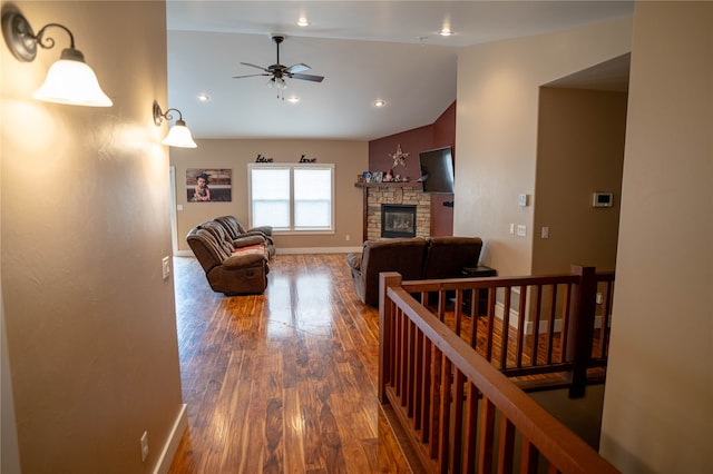 living room featuring a fireplace, dark hardwood / wood-style floors, and ceiling fan