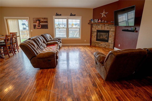 living room with a fireplace and dark wood-type flooring