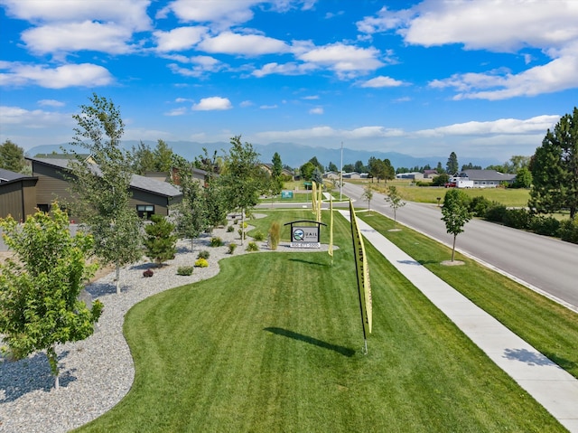 view of property's community with a yard and a mountain view