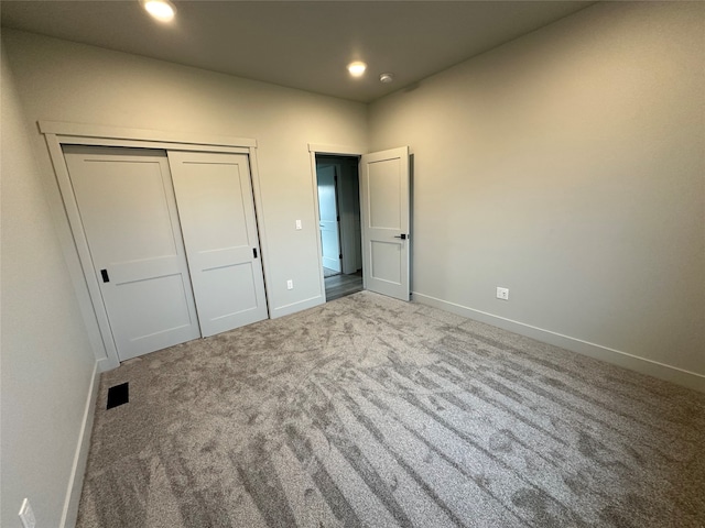 unfurnished bedroom with a closet and carpet flooring