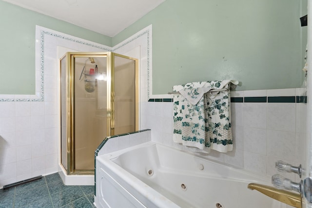 bathroom with shower with separate bathtub, tile walls, and tile patterned floors