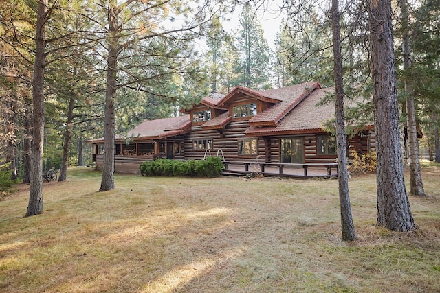 log cabin with a front lawn and a wooden deck