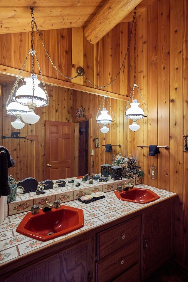 bathroom featuring lofted ceiling, wood walls, and vanity