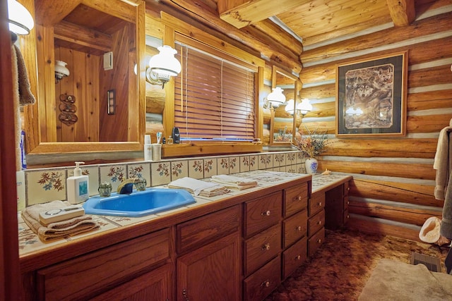 bathroom featuring log walls, beam ceiling, and vanity