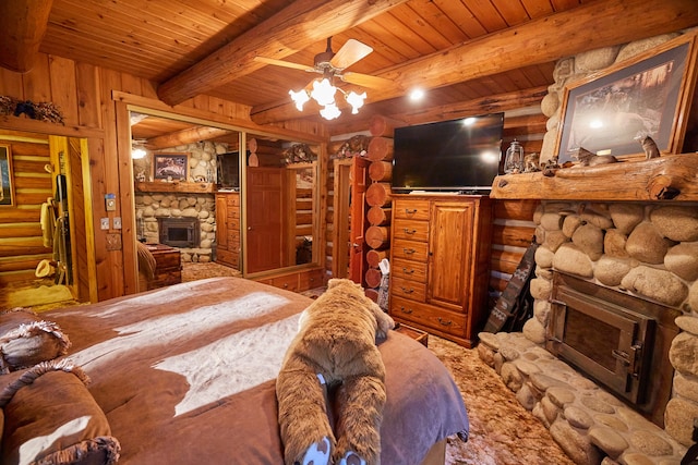 bedroom featuring beamed ceiling, a fireplace, wooden walls, and wooden ceiling