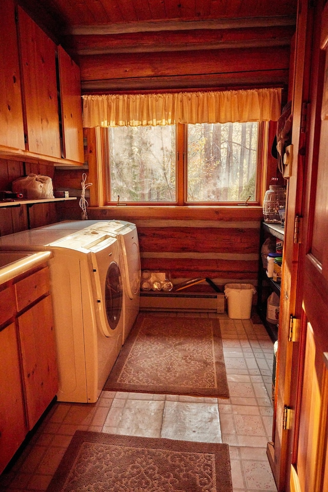 clothes washing area with washer and clothes dryer, cabinets, and a baseboard heating unit