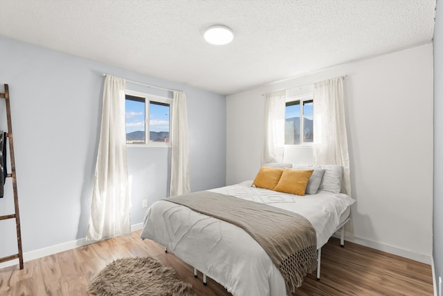 bedroom with wood-type flooring and a textured ceiling