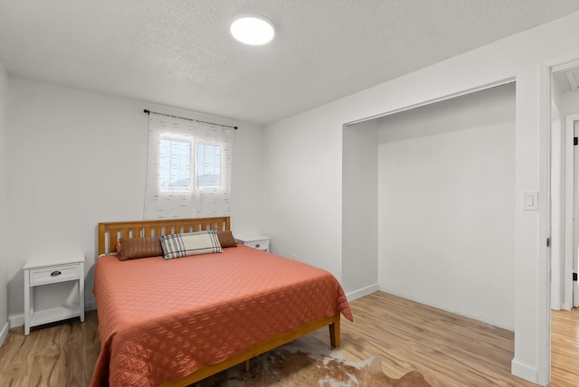 bedroom featuring light wood-type flooring and a textured ceiling