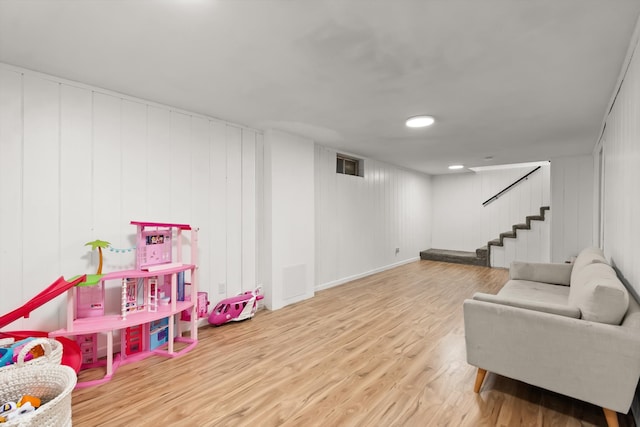 game room featuring wood walls and wood-type flooring