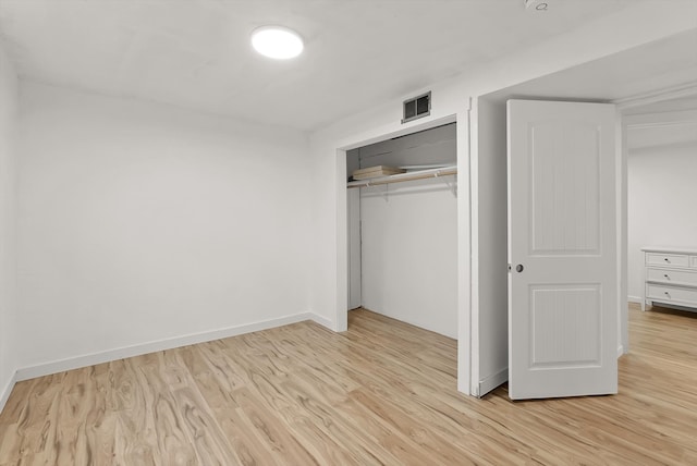 unfurnished bedroom featuring a closet and light hardwood / wood-style flooring