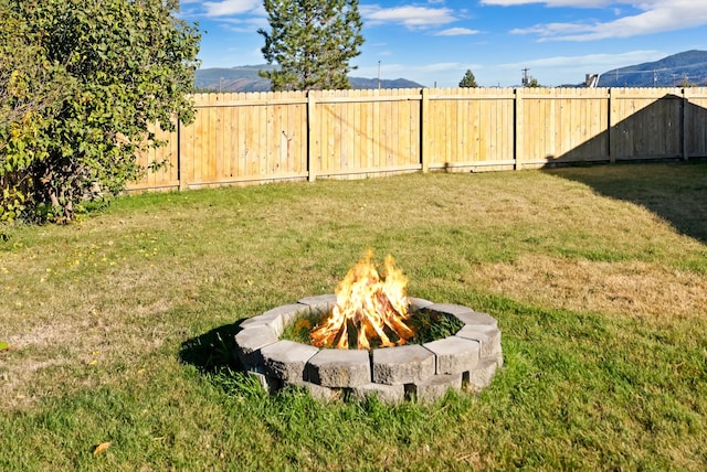 view of yard featuring a mountain view and a fire pit