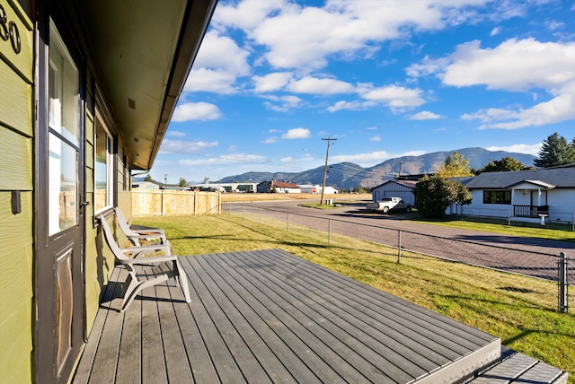 wooden deck with a yard and a mountain view